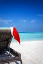 A Santa Claus hat hanging on a sun lounger chair Royalty Free Stock Photo