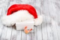 Santa Claus hat over gift box on wooden background. Winter holidays concept. New Year of rooster.