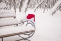 Santa Claus hat, resting on the bench in snow. Christmas celebrate concept Royalty Free Stock Photo