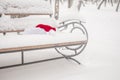 Santa Claus hat, resting on the bench in snow. Christmas celebrate concept Royalty Free Stock Photo