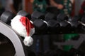 Santa Claus hat on stand with dumbbells