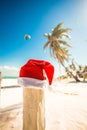 Santa Claus hat on white sandy beach in sunny day Royalty Free Stock Photo