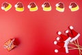Santa Claus hats arranged in a row at the top, a wrapped gift in the bottom left corner and Santa Claus hats on a wooden stick lyi Royalty Free Stock Photo