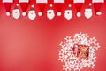 Santa Claus hats and Santa Claus faces made of material arranged in a row on top and a wrapped gift in the lower right corner lyin Royalty Free Stock Photo