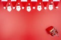 Santa Claus hats and Santa Claus faces made of material arranged in a row on top and a wrapped gift in the lower right corner, iso Royalty Free Stock Photo