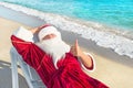 Santa Claus have e rest in chaise longue on sea beach Royalty Free Stock Photo