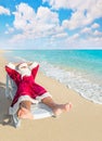 Santa Claus have a rest in chaise longue on sea beach Royalty Free Stock Photo