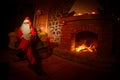 Santa Claus having a rest in a comfortable chair near the fireplace at home Royalty Free Stock Photo