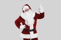 Santa Claus with headphones listening to Christmas music on grey background Royalty Free Stock Photo