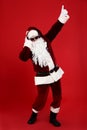 Santa Claus with headphones listening to Christmas music on red background Royalty Free Stock Photo