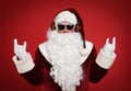 Santa Claus with headphones listening to Christmas music on red background Royalty Free Stock Photo