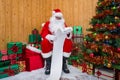 Santa Claus in a grotto checking the naughty or nice list Royalty Free Stock Photo