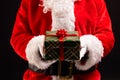 Santa claus holding christmas present with copy space on black background Royalty Free Stock Photo