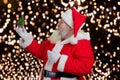 Santa Claus holding decorative Christmas tree.