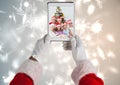 Santa claus holding a digital tablet with photo of christmas family Royalty Free Stock Photo