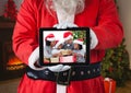 Santa claus holding a digital tablet with photo of christmas family Royalty Free Stock Photo