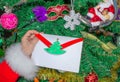 Santa Claus is holding a letter at the North Pole in Lapland - against the background of Christmas trees Royalty Free Stock Photo