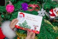 Santa Claus is holding a letter at the North Pole in Lapland - against the background of Christmas trees Royalty Free Stock Photo