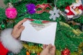 Santa Claus is holding a letter at the North Pole in Lapland - against the background of Christmas trees Royalty Free Stock Photo