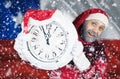 Santa Claus holds a clock in his hands against the background of the flag of Chile