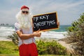 Santa Claus holds gift boxes with the ocean on backgraund Royalty Free Stock Photo