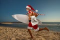 Santa Claus holds towel and surfboard on the beach ÃÂ¾n holiday. Christmas party. Christmas concept Royalty Free Stock Photo