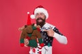 Santa Claus Ive been good. Santa point finger at reindeer toy. Happy bearded man with santa look. Secret santa gift Royalty Free Stock Photo