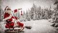 Santa Claus with a lantern and sack of presents on the sled with a blurred snowy winter Christmas day background. Royalty Free Stock Photo