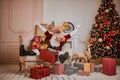 Santa Claus lay down to rest on the sofa with a bunch of gifts near the fireplace and christmas tree . New year and Merry Royalty Free Stock Photo