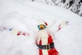 Santa Claus lies on the snow in winter for Christmas Royalty Free Stock Photo