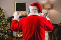 Santa claus listening to music on headphones at home during christmas time Royalty Free Stock Photo