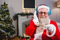 Santa Claus listening to music on headphones Royalty Free Stock Photo