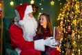 Santa Claus with a little cute girl open magical gift box in the room. Christmas time Royalty Free Stock Photo