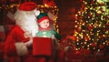 Santa Claus and little elf with magic gift for Christmas Royalty Free Stock Photo