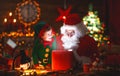 Santa Claus and little elf with magic gift for Christmas Royalty Free Stock Photo