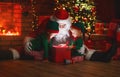 Santa Claus and little elves with magic gift for Christmas Royalty Free Stock Photo