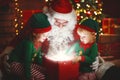 Santa Claus and little elves with magic gift for Christmas Royalty Free Stock Photo