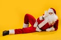 Santa Claus lying on the floor in impudent shameless manner, holding his glasses