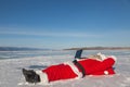 Santa Claus lying on the snow, looking at laptop news Royalty Free Stock Photo