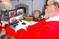 Santa claus making laptop christmas video call with waving diverse families and friends