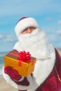 Santa Claus with many golden gifts relaxing at beach