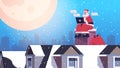 Santa claus in mask sitting on roof using laptop happy new year merry christmas holidays celebration concept Royalty Free Stock Photo