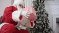 Santa Claus opening his sack and putting presents under the Christmas tree Royalty Free Stock Photo