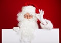 Santa Claus pointing in blank advertisement banner isolated on r Royalty Free Stock Photo