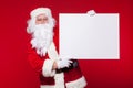 Santa Claus pointing in blank advertisement banner isolated on red background with copy space Royalty Free Stock Photo