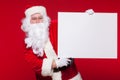 Santa Claus pointing in blank advertisement banner isolated on red background with copy space Royalty Free Stock Photo