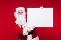 Santa Claus pointing in blank advertisement banner isolated on red background with copy space Royalty Free Stock Photo