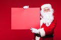 Santa Claus pointing in blank advertisement banner isolated on red background with copy space red leaf Royalty Free Stock Photo