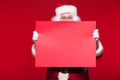 Santa Claus pointing in blank advertisement banner isolated on red background with copy space red leaf Royalty Free Stock Photo