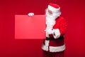 Santa Claus pointing in blank advertisement banner isolated on red background with copy space red leaf Royalty Free Stock Photo